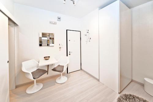 a white bathroom with a table and two chairs at Casanova Apartment in Venice