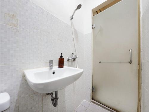 a white bathroom with a sink and a shower at RedDoorz @ Pandu Raya Bogor in Bogor
