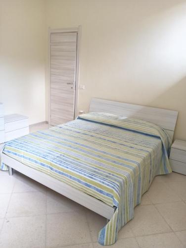 a bed with a striped blanket on it in a bedroom at Cefalù Station House in Cefalù