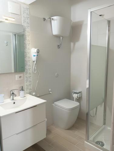 a white bathroom with a toilet and a shower at Cefalù Station House in Cefalù