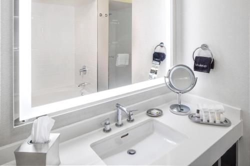 a white bathroom with a sink and a mirror at Grand Bay Hotel San Francisco in Redwood City
