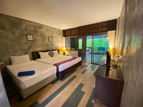 a hotel room with two beds and a television at Crescent Bay Resort in Ko Samed