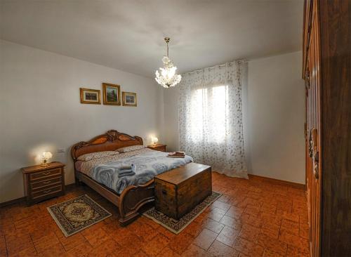 a bedroom with a bed and a window with a chandelier at Il loggiato del chianti in Cavriglia