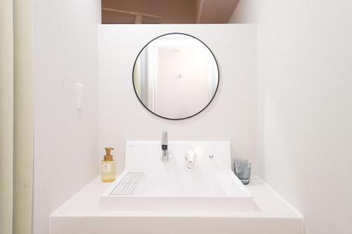 a bathroom with a white sink and a mirror at Evergreen hotel yotsuya in Tokyo