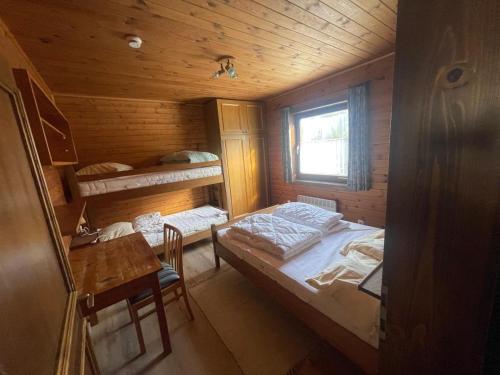 a room with a bed and a table in a cabin at Knusperhäuschen Nassfeld in Sonnenalpe Nassfeld
