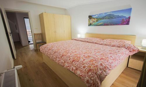 a bedroom with a bed and a painting on the wall at APARTAMENT DOMINA - deluxe - self check-in, aer conditionat, oază de liniște, sentimentul de acasă in Sînnicolau Mare