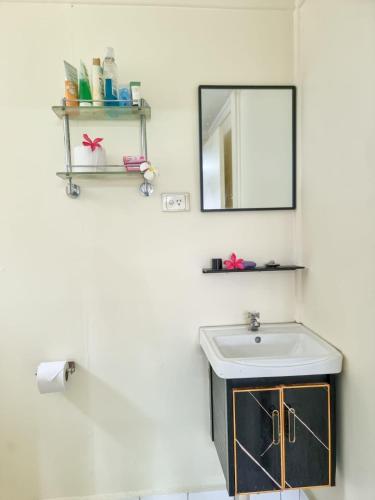 a bathroom with a sink and a mirror at Panatina Hilltop Downstairs Unit in Honiara