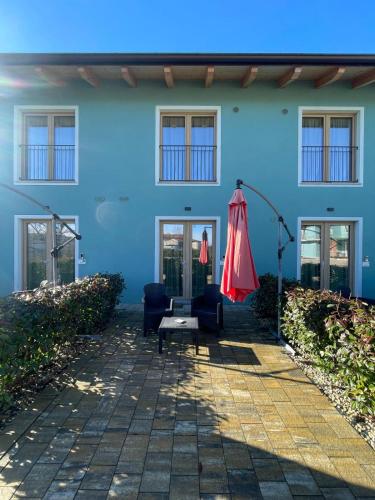 a blue building with two chairs and an umbrella at Le Ghie in Mondovì