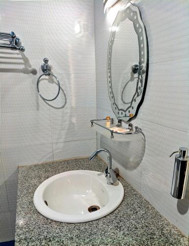 a bathroom with a toilet with a sink at Hotel Ech Aar, Kargil in Kargil