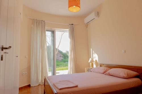 a bedroom with a bed and a large window at Mulberry House by the Sea Νέα Μάκρη in Nea Makri