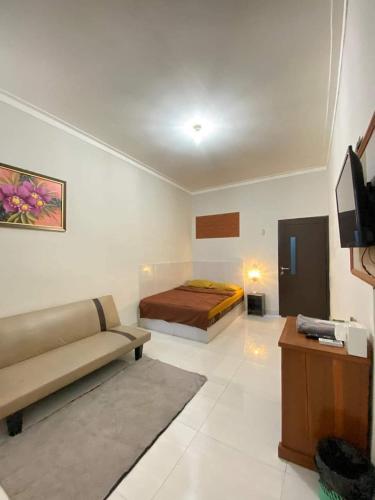 a living room with a couch and a bed in it at Baga Guesthouse in Kanggraksan