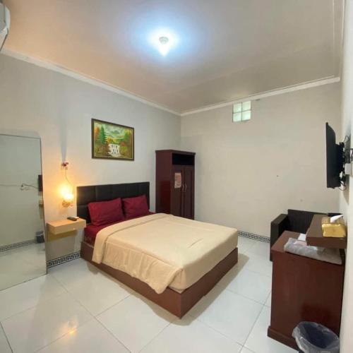 a bedroom with a bed and a television in it at Baga Guesthouse in Kanggraksan