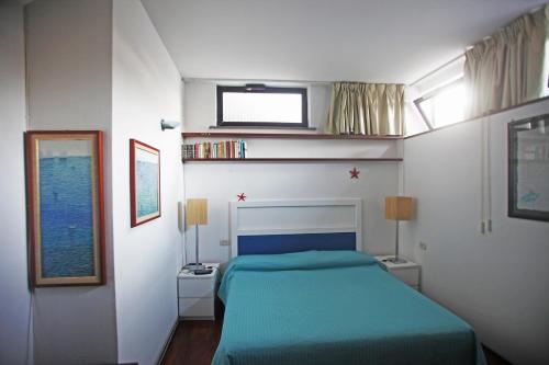 カプリにあるResidenza L'Isola Capriのベッドルーム(青いベッド1台、窓付)