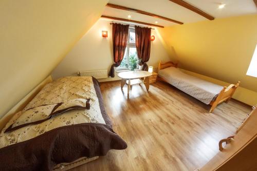 a bedroom with two beds and a table and a window at Dom Maciejówka in Polanica-Zdrój