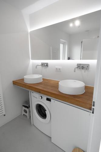 a bathroom with two sinks and a washing machine at Heggerank 5a in Nieuwvliet