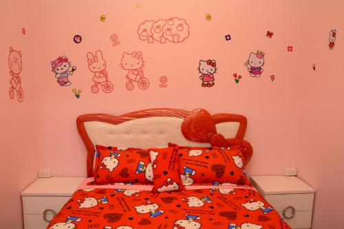 a bedroom with a bed with hello kitty stickers on the wall at 安可的家 小孩及寵物免費 恆春老街夜市 屏東縣民宿0497 in Hengchun