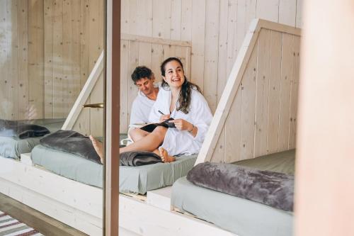 a man and a woman sitting on bunk beds at Wolter Landhaus in Vipiteno