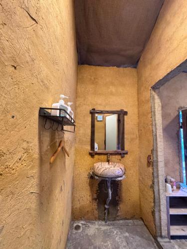 a small bathroom with a sink and a mirror at Then Pa village in Loung Co