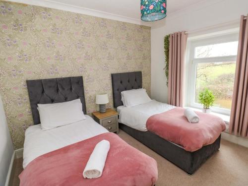 a bedroom with two beds and a window at Burry House in Swansea