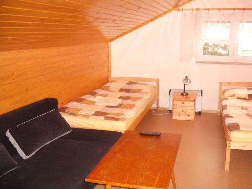 a room with a bed and a couch and a table at Hostinec U Valentů in Červená Voda