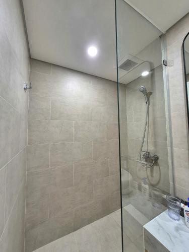 a shower with a glass door in a bathroom at My SunArt in Quang Ãm