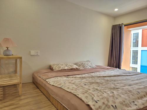 a bedroom with a bed and a window at My SunArt in Quang Ãm
