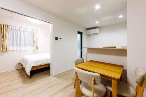 a bedroom with a bed and a table and chairs at Anecis笠取町1 in Nagoya