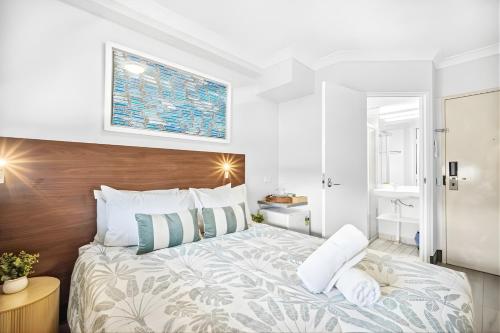 a bedroom with a large bed with a wooden headboard at Darwin CBD Escape-Cosy and Central in Darwin