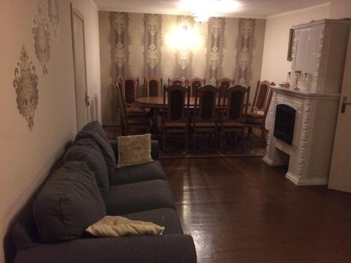 a living room with a couch and a table and chairs at Rooms for Rent near Vilnius in Bezdonys