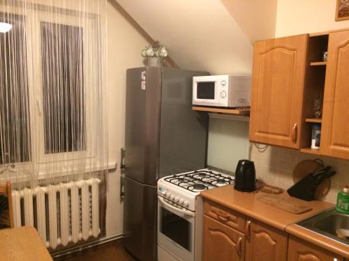 a small kitchen with a stove and a microwave at Rooms for Rent near Vilnius in Bezdonys