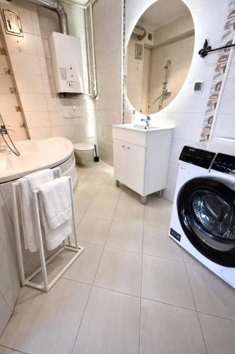 a white bathroom with a washing machine in it at Plac 14- Apartamenty i pokoje w centrum in Świnoujście