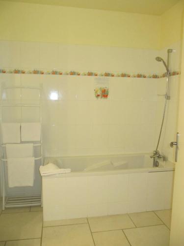 une salle de bain blanche avec une baignoire et une douche dans l'établissement Hôtel Le Colombier, à Saint-Pantaléon-de-Larche