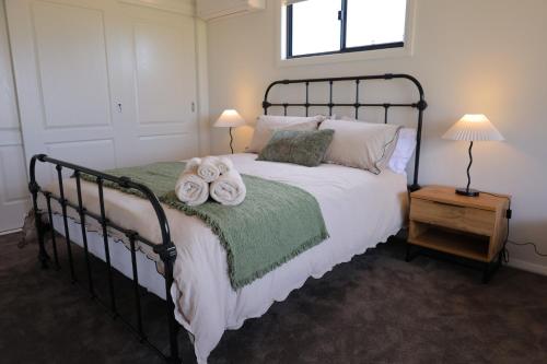 a bedroom with a bed with two towels on it at Rivergums Cottage in Dubbo