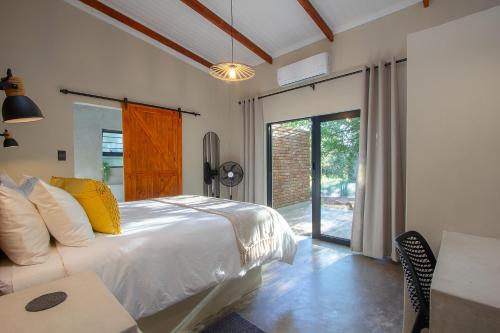 a bedroom with a bed and a sliding glass door at Spoorzicht in Marloth Park