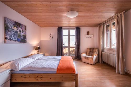 Schlafzimmer mit einem Bett mit Holzdecke in der Unterkunft Chalet Cecile in Interlaken