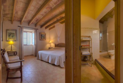 a bedroom with a bed and a bathroom with a toilet at La Galera Deià in Deia