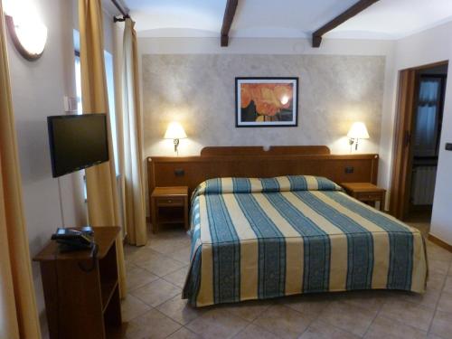 a bedroom with a bed and a flat screen tv at La Cascina Di Villa Due in Narzole