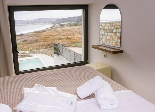 a bedroom with a bed and a large window at Relaxury Villa III in Karpathos