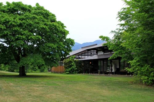 a black building with a tree in front of it at Bunanoyado Koase in Aga