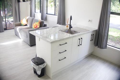 a kitchen with a sink and a couch at Purotu Villas in Avarua