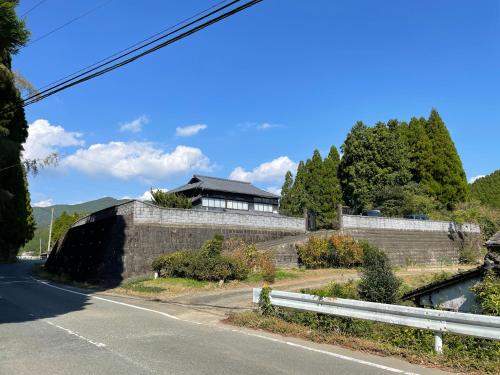 a house on a retaining wall next to a road at 陽月 Yo-Getsu in Yamaga