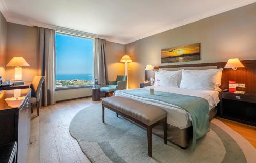 a hotel room with a large bed and a large window at Kaya İstanbul Fair & Convention in Istanbul