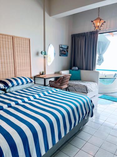 a bedroom with two beds and a table and a window at SunsetSpa PD in Port Dickson