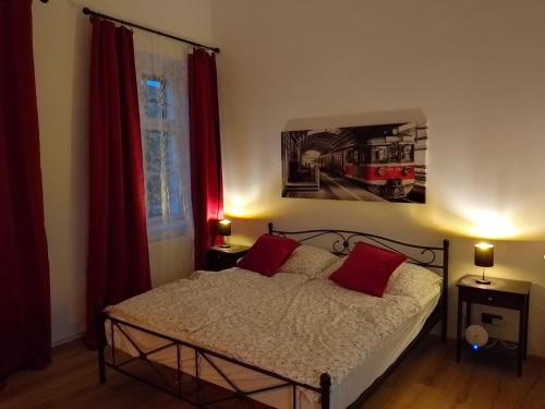 a bedroom with a bed with red curtains and a train picture at Railway cottage in Dürnstein in Dürnstein