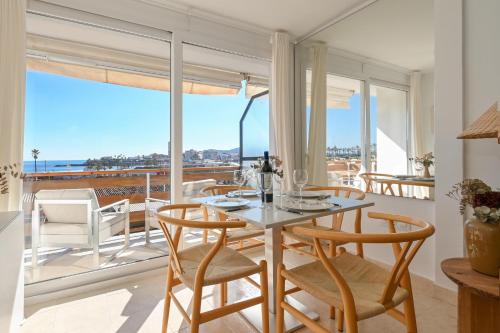 a dining room with a table and chairs and a balcony at Hawaii in Jávea
