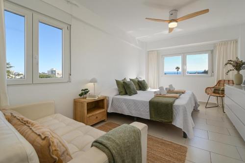 a white bedroom with a bed and a couch at Hawaii in Jávea