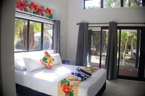 a bedroom with two beds and a large window at Purotu Villas in Avarua