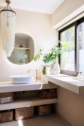 a bathroom with a sink and a mirror at I Boho Sun Oceanfront Apartment in Icod de los Vinos