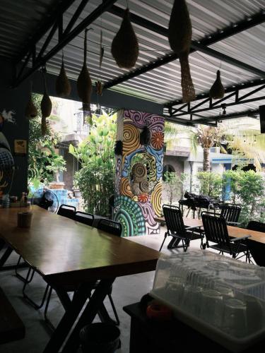 a restaurant with tables and chairs and a colorful wall at Laydaman Art Homestay in Ao Luk