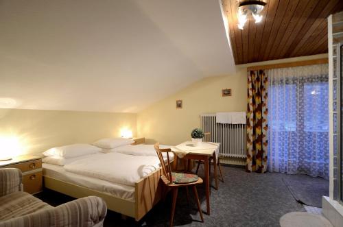 ニーダーンジルにあるFerienwohnung Nussbaumerのベッド、テーブル、椅子が備わるホテルルームです。